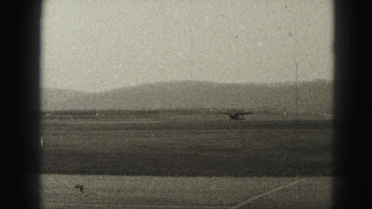 A small propeller aircraft appears distant on a runway near Harrisburg, Pennsylvania, in grainy 1946 home-movie footage.