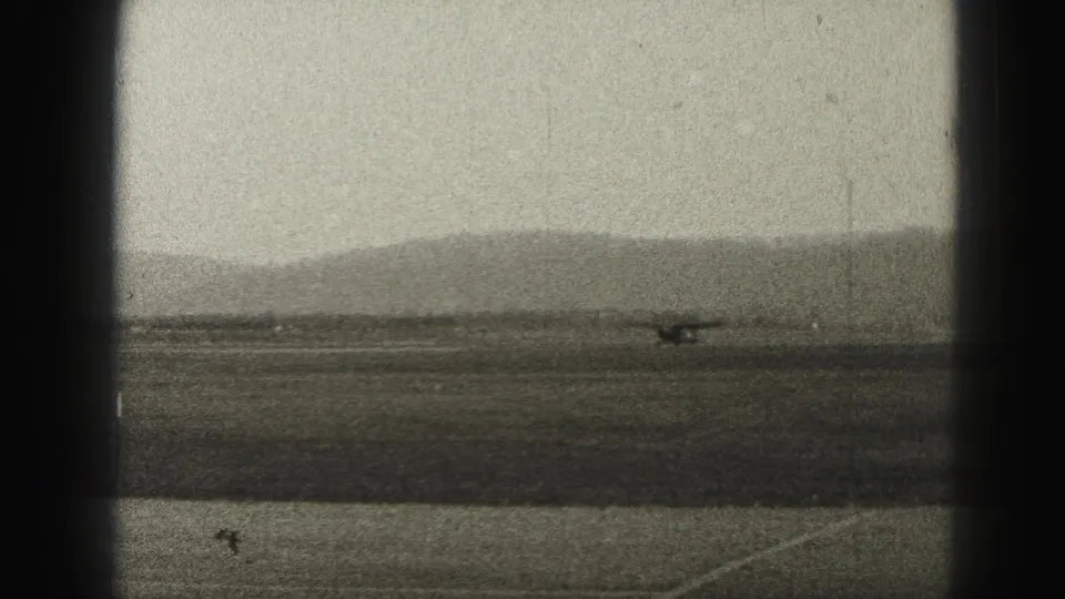 A small propeller aircraft appears distant on a runway near Harrisburg, Pennsylvania, in grainy 1946 home-movie footage.