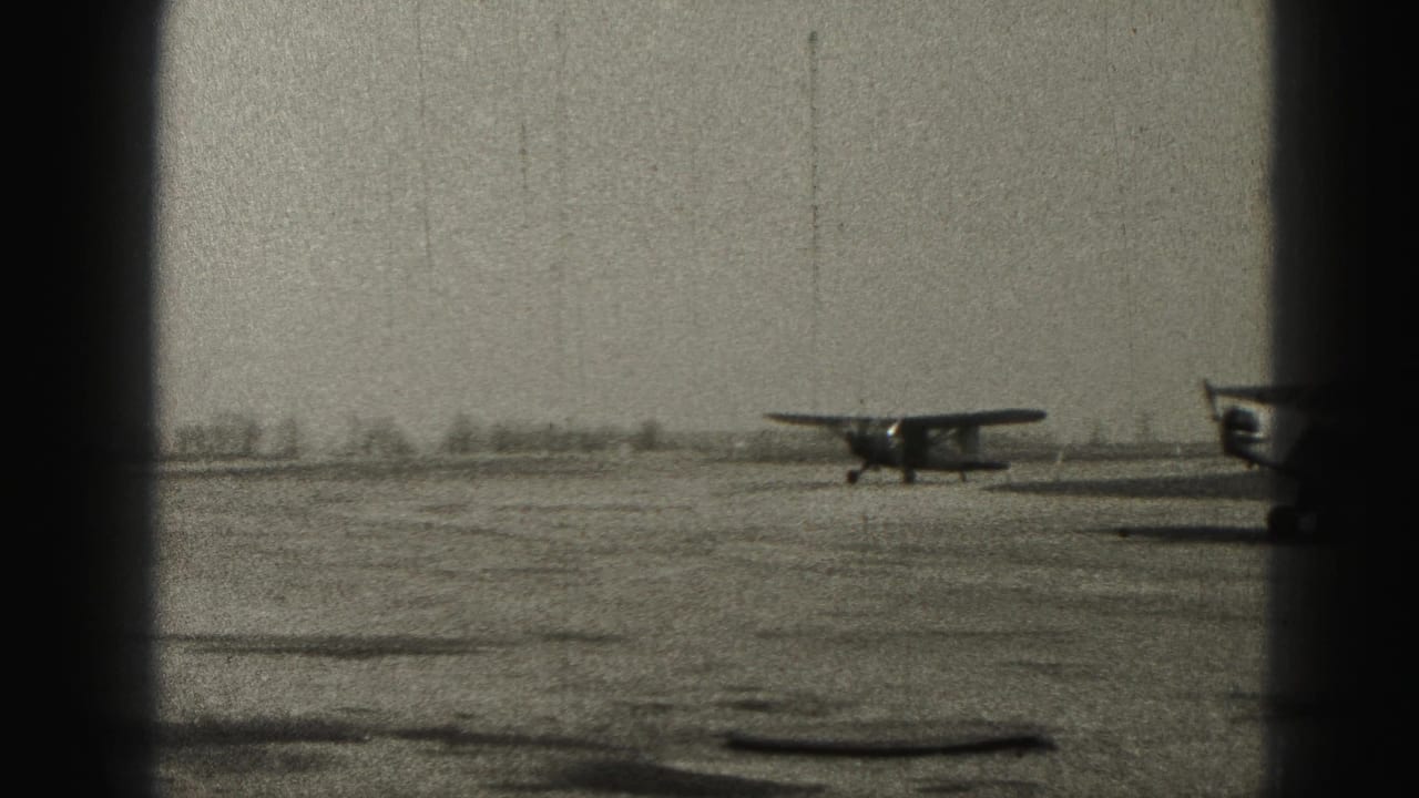 A small propeller aircraft taxis on a Harrisburg-area runway in 1946, seen through dark vertical framing on black-and-white 8mm film.