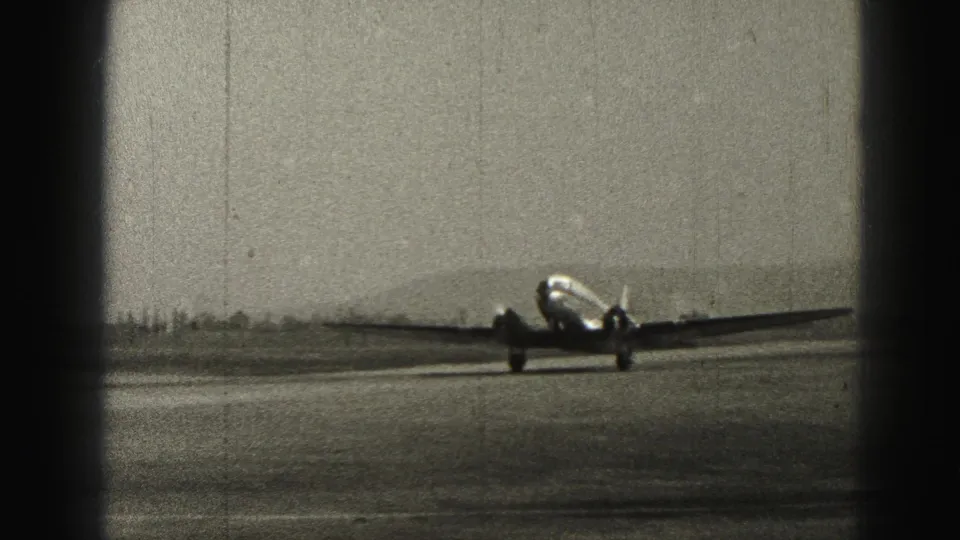 The twin-engine aircraft sits low on the runway during landing or early taxi in 1946 Harrisburg aviation footage.