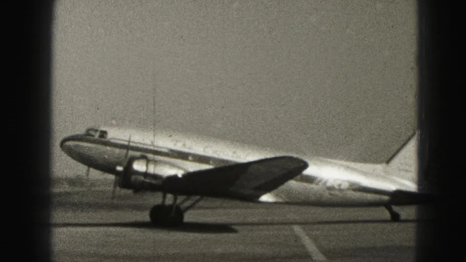 A Capital Airlines DC-3 sits on the Harrisburg tarmac in 1946, seen in black-and-white 8mm footage from a distance.