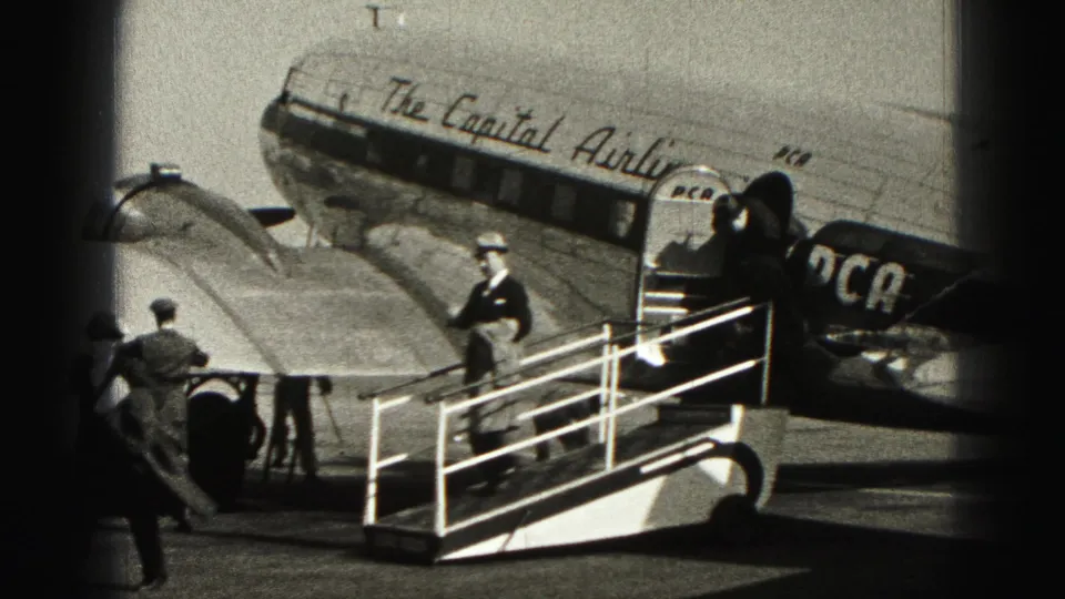 Passengers in coats and hats gather by mobile stairs beside the Capital Airlines DC-3 at Harrisburg in 1946.