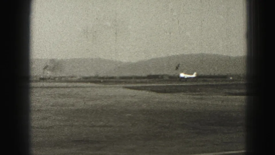 Near the end of the clip, the small airplane is seen farther down the Harrisburg runway against hazy hills and worn 8mm film texture.