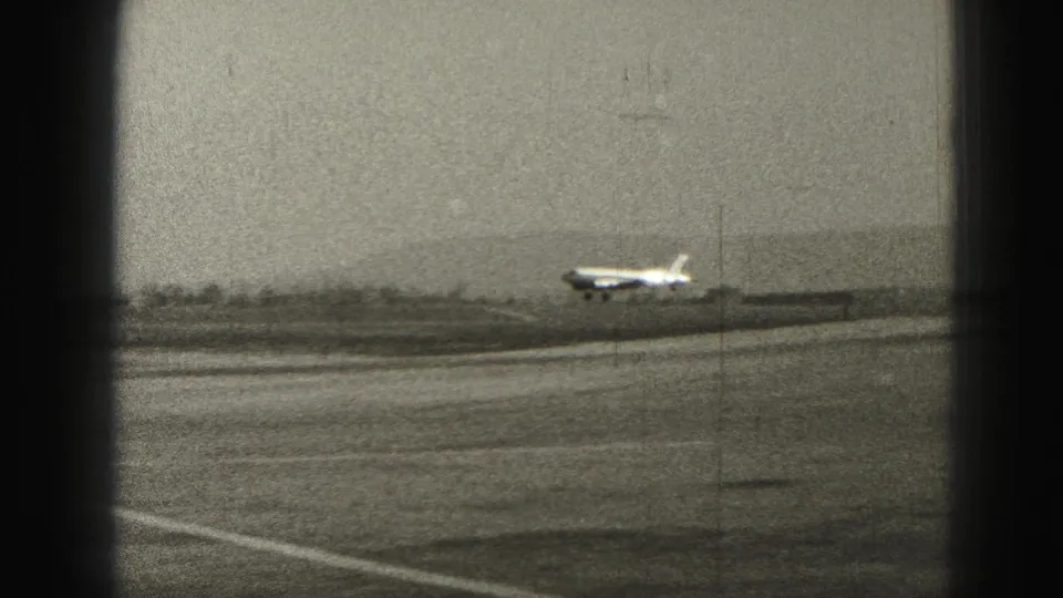 A small propeller airplane appears to lift off from the Harrisburg runway in a 1946 black-and-white home-movie frame.