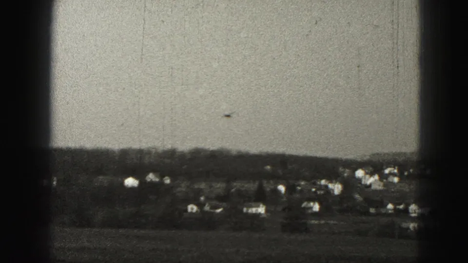 Final 8mm frame shows a small airplane crossing above a distant suburban horizon near Harrisburg, Pennsylvania.