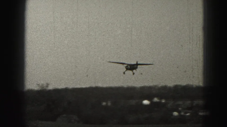 A small propeller plane approaches over a rural horizon in Harrisburg-area 1946 home-movie footage.