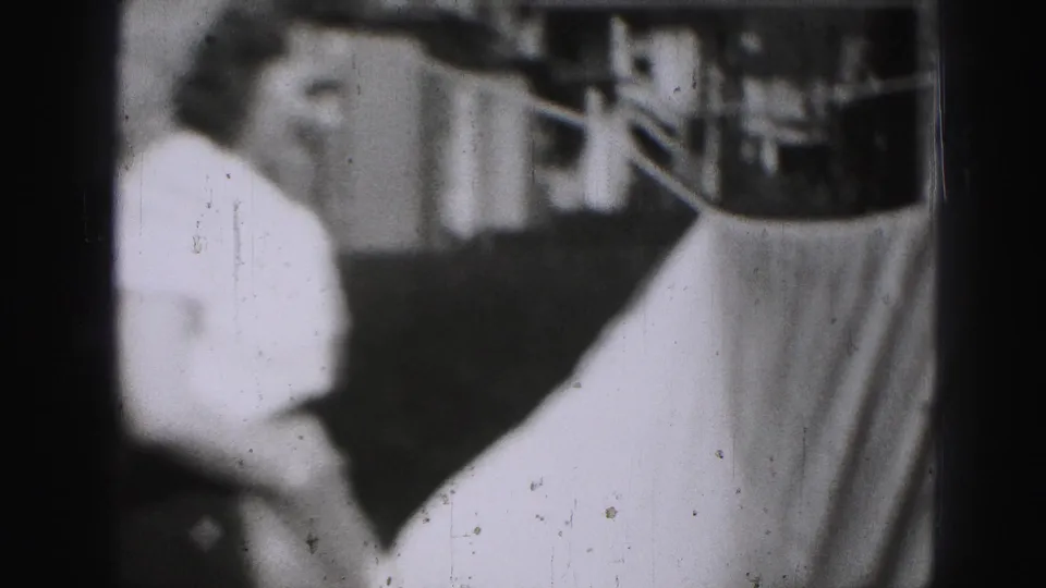 In 1946 Harrisburg home-movie footage, a woman stands near a clothesline with a light sheet hanging in a backyard.