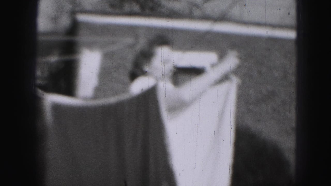 In 1946 Harrisburg home-movie footage, a woman stands near hanging laundry and a backyard fence.