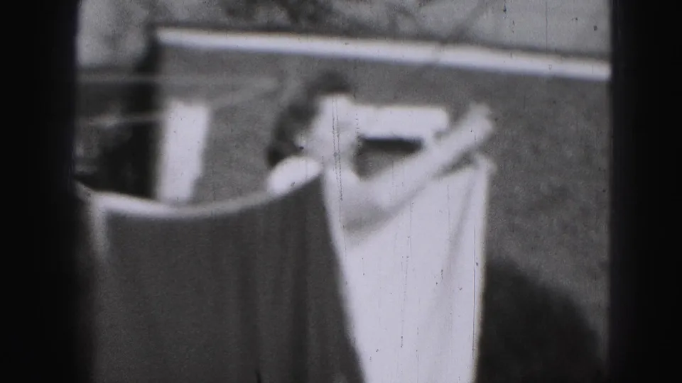 In 1946 Harrisburg home-movie footage, a woman stands near hanging laundry and a backyard fence.