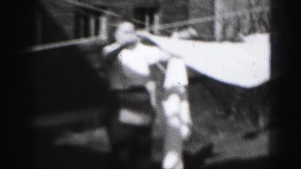 In the final frame, the woman stands beneath the line while light fabric hangs across the yard in the 1946 Harrisburg clip.