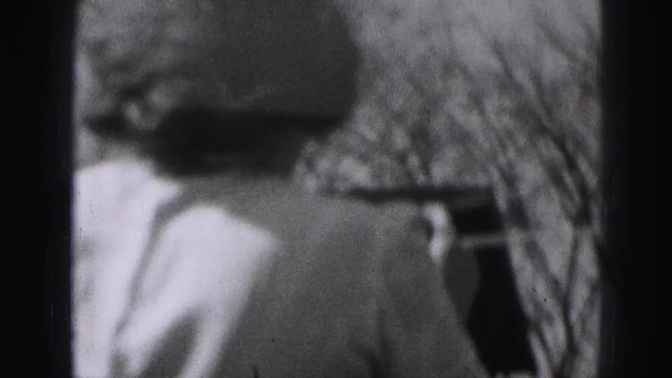 The woman is seen from behind in the Harrisburg backyard, standing close to the clothesline with bare tree branches beyond.