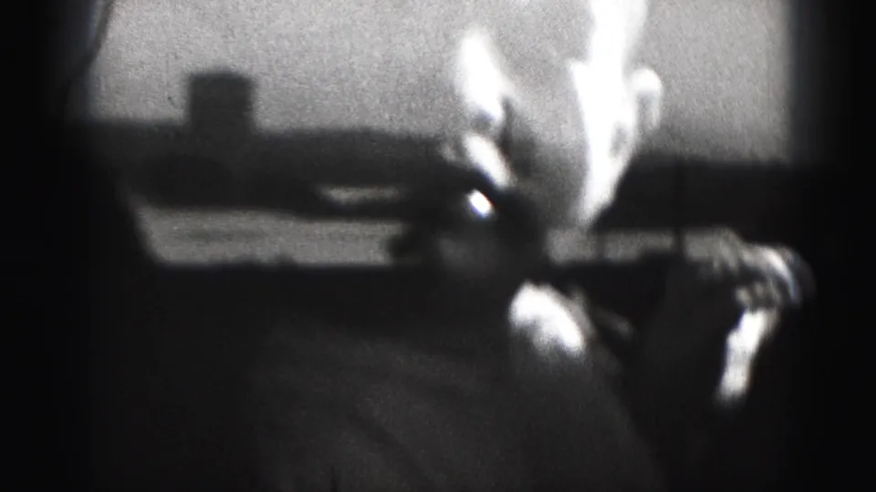 A soft, high-contrast 1946 Harrisburg home-movie frame shows the baby leaning down, with the light shirt prominent in the foreground.