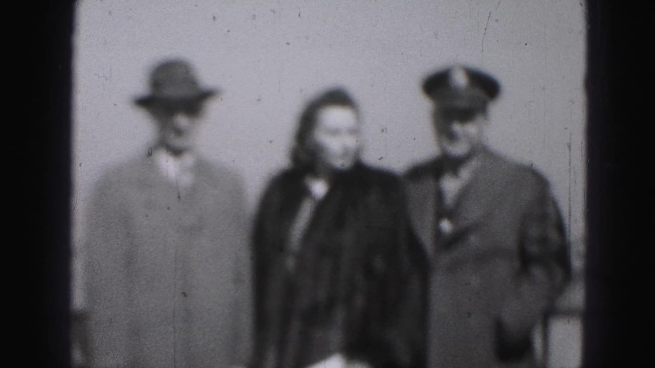 The same three adults continue posing, with the woman centered and both men facing forward.