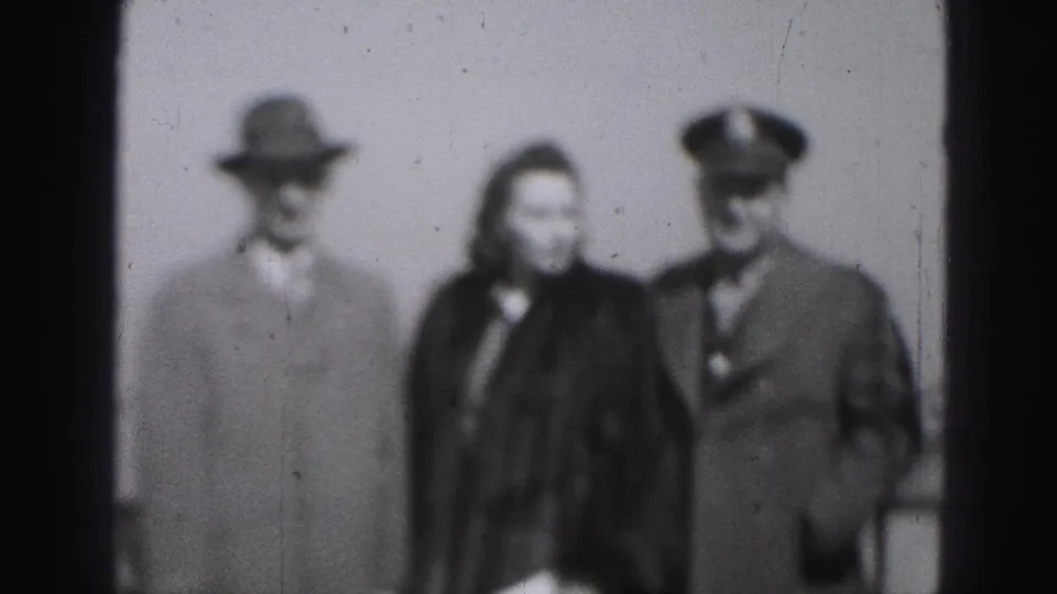 The Harrisburg 1946 frame shows the trio still facing the camera, with formal coats and a peaked cap visible in soft focus.