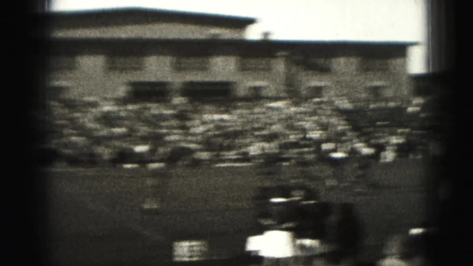 Harrisburg, Pennsylvania 1946 home-movie frame showing a distant field match, sideline crowd, bleachers, and soft 8mm blur.