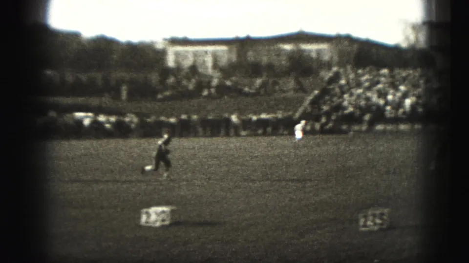 Harrisburg 1946 home-movie frame of a player crossing the grass field as spectators fill the far bleachers.