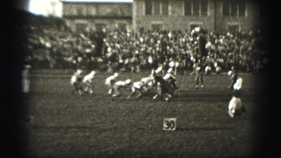 1946 Harrisburg football game scene with players set near the 30-yard marker and spectators filling the bleachers in the background.