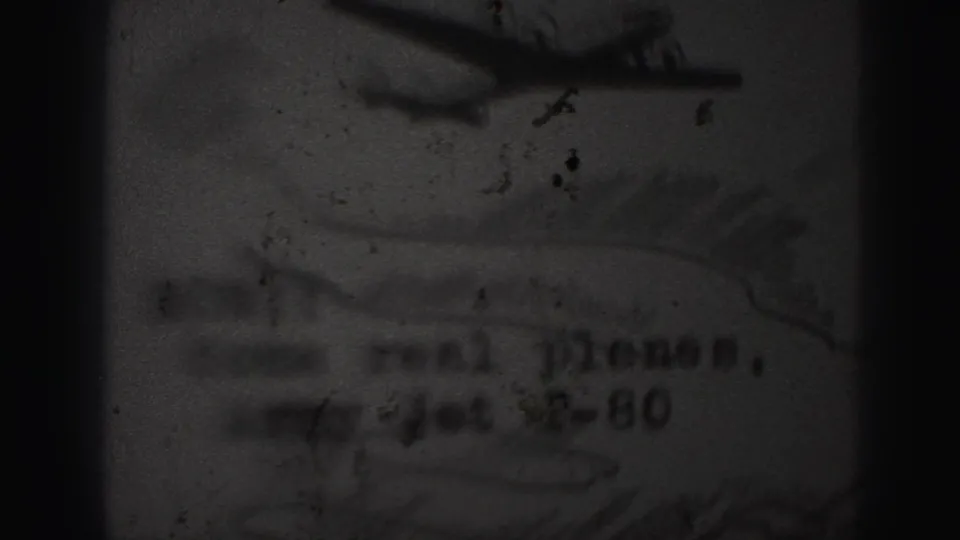 1946 Harrisburg home-movie frame showing a blurred airplane-like graphic above typed wording on a paper flyer or letter.