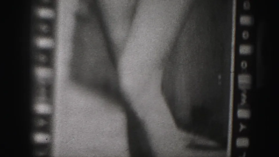1946 Harrisburg home-movie frame with a close cropped view of a woman's legs and torso in a fitted garment.