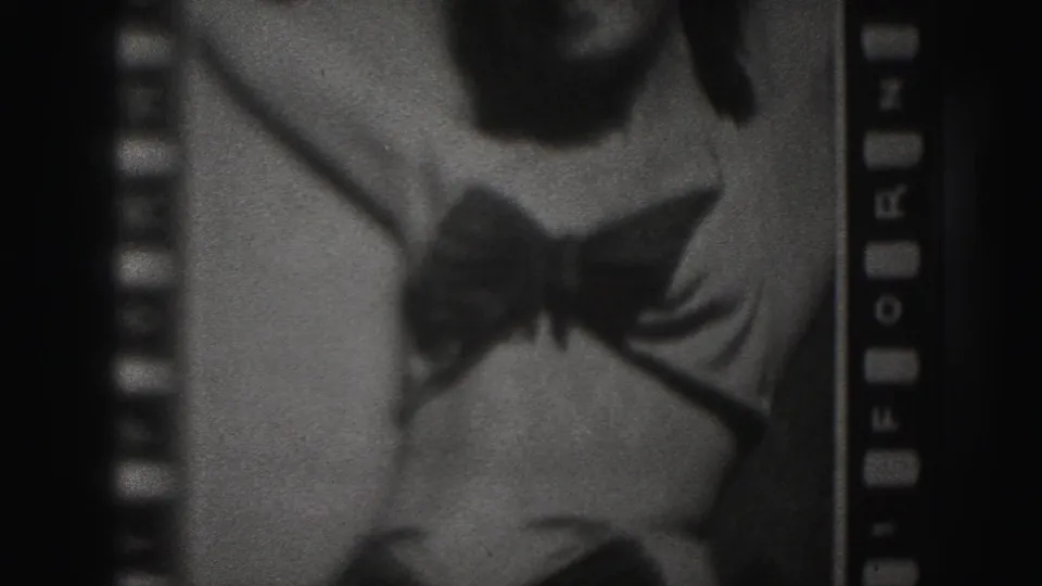 1946 Harrisburg 8mm frame showing an adult woman posing in a dark one-piece bathing suit, partly cropped within visible film edges.