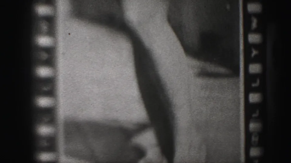 Harrisburg 1946 home-movie frame with a soft poster close-up of a woman's legs and adjacent printed figure detail.