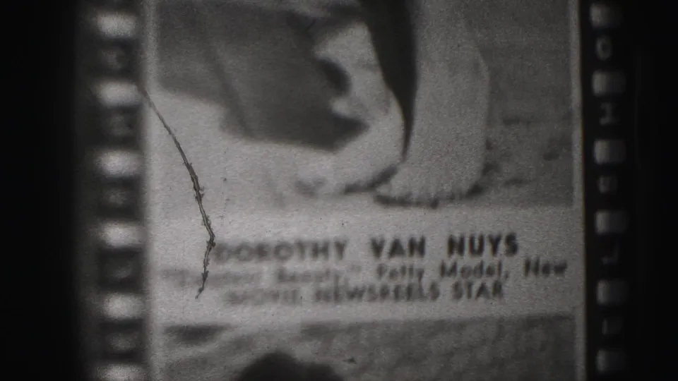 Harrisburg 1946 8mm frame showing the poster caption text for Dorothy Van Nuys below the printed model's legs.