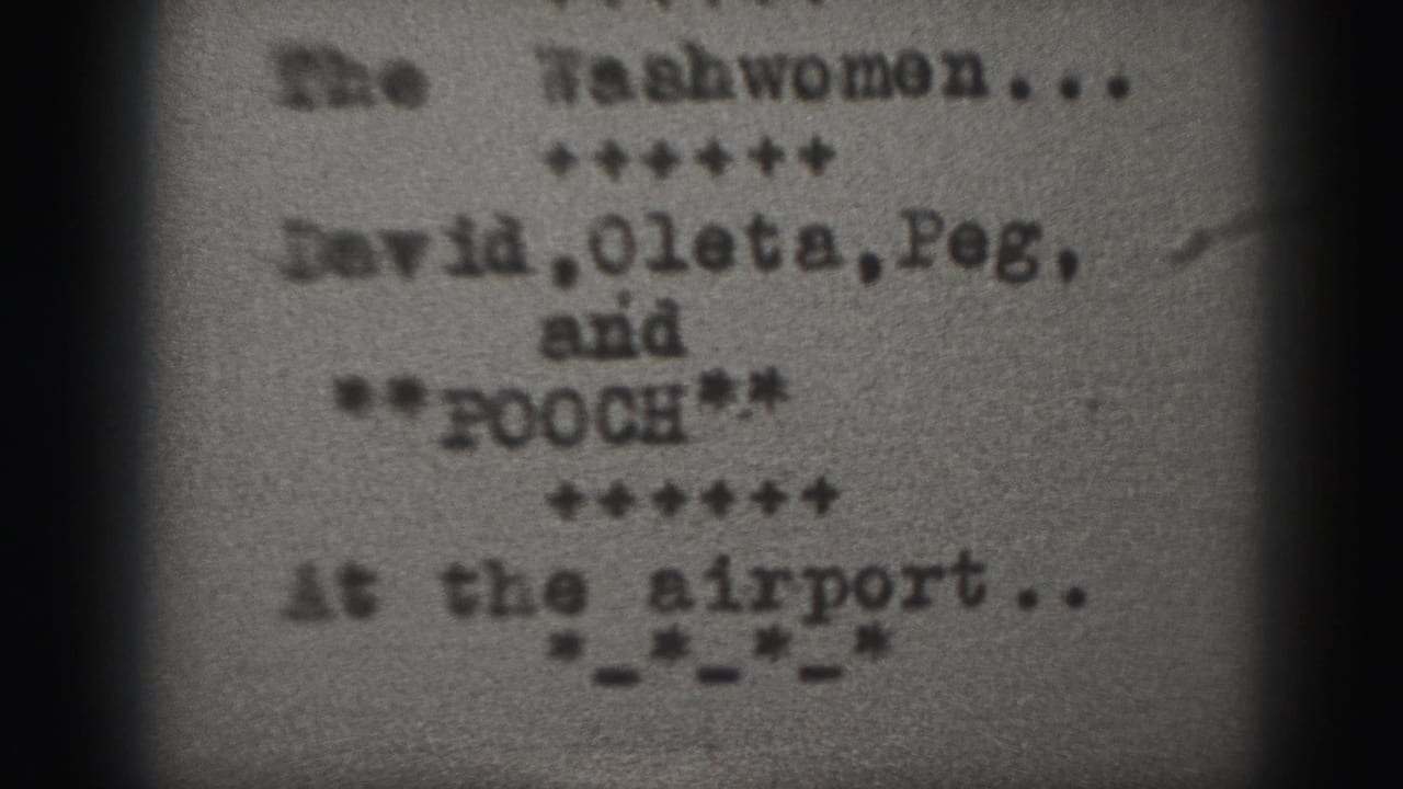 1946 Harrisburg 8mm frame with a blurred typewritten title card for The Washwomen and cast-name text on grainy film.