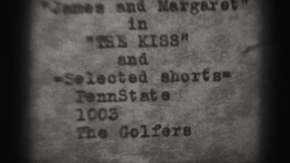 Soft 8mm frame from the Harrisburg reel with the The Kiss program card and selected-shorts listing visible on paper.