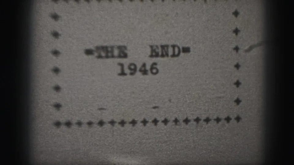 Black-and-white 8mm frame of the 1946 end card, with typed lettering centered within a dotted and plus-sign border.