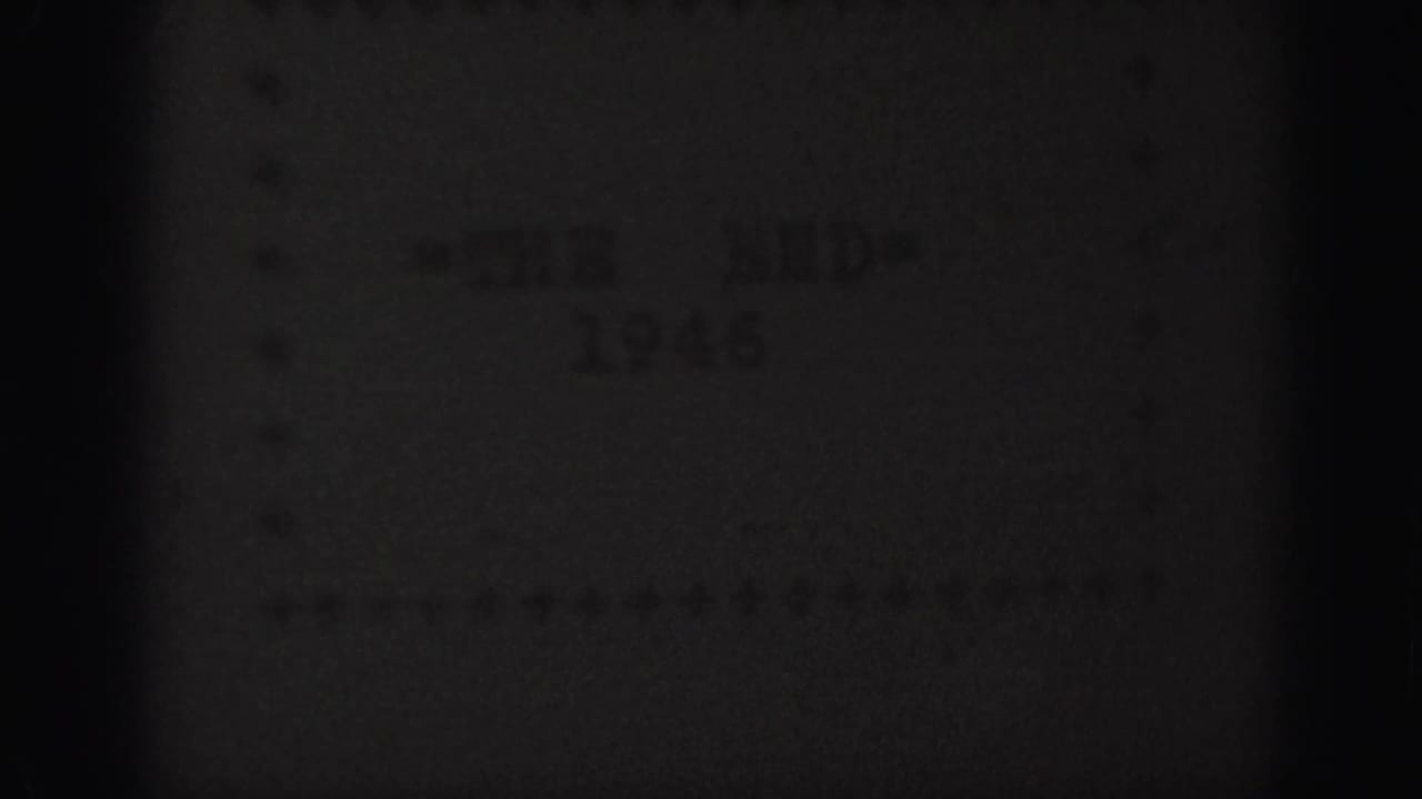Dark, low-exposure frame with faint end-card text and film grain.