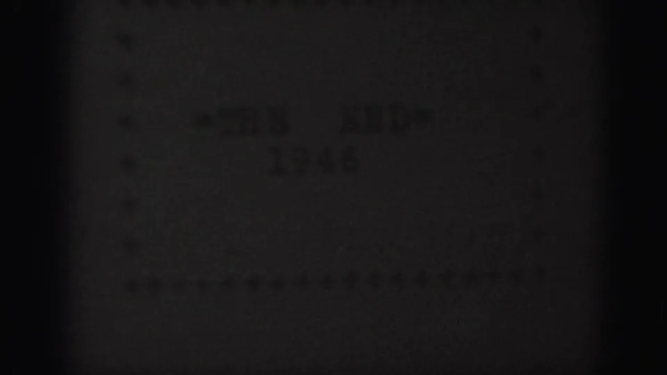 Underexposed 8mm frame from the 1946 home movie ending, with faint title-card text barely visible through grain and shadow.