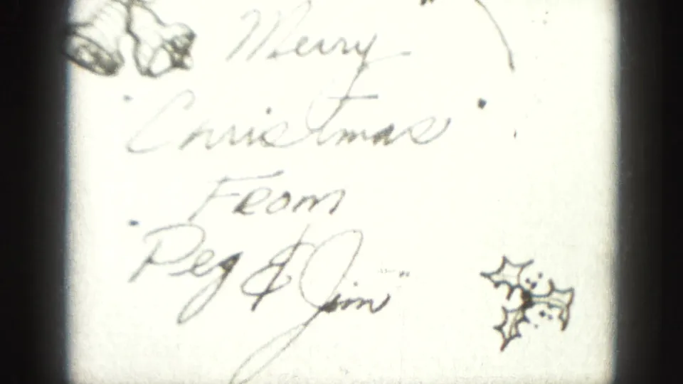 Handwritten Christmas title card from the Harrisburg 1946 home movie, reading Merry Christmas From Peg & Jim with holly decoration.
