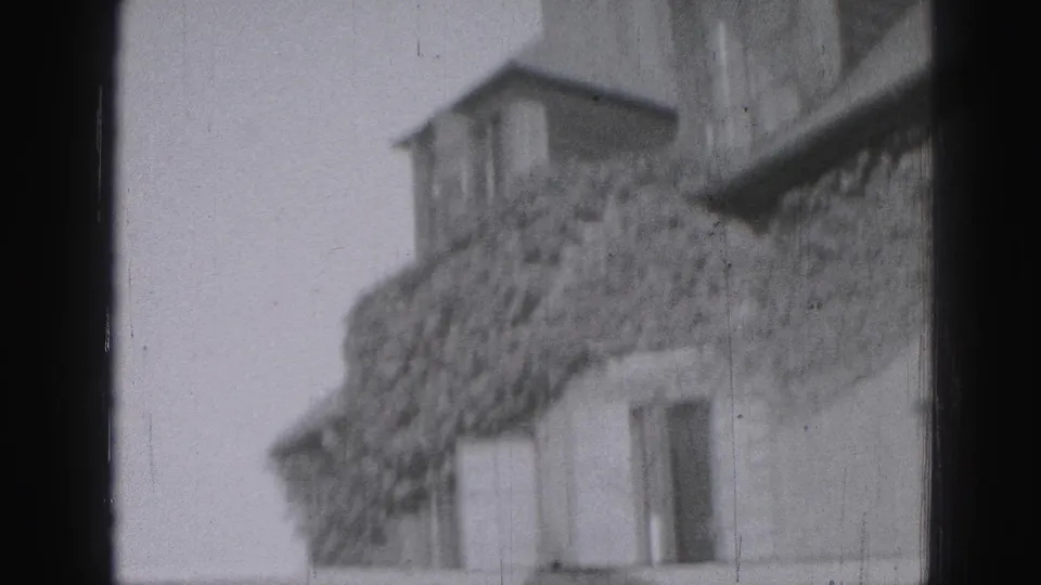 1946 Harrisburg home-movie view of an ivy-covered stone facade with roofline and window openings.