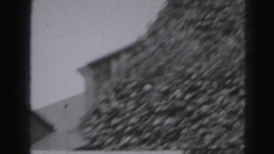 Black-and-white 1946 Harrisburg home-movie frame showing an ivy-covered house wall and partial roofline.