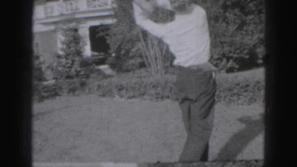 The final frame catches the man finishing his golf swing, arms high, in front of the residential lawn and house exterior.