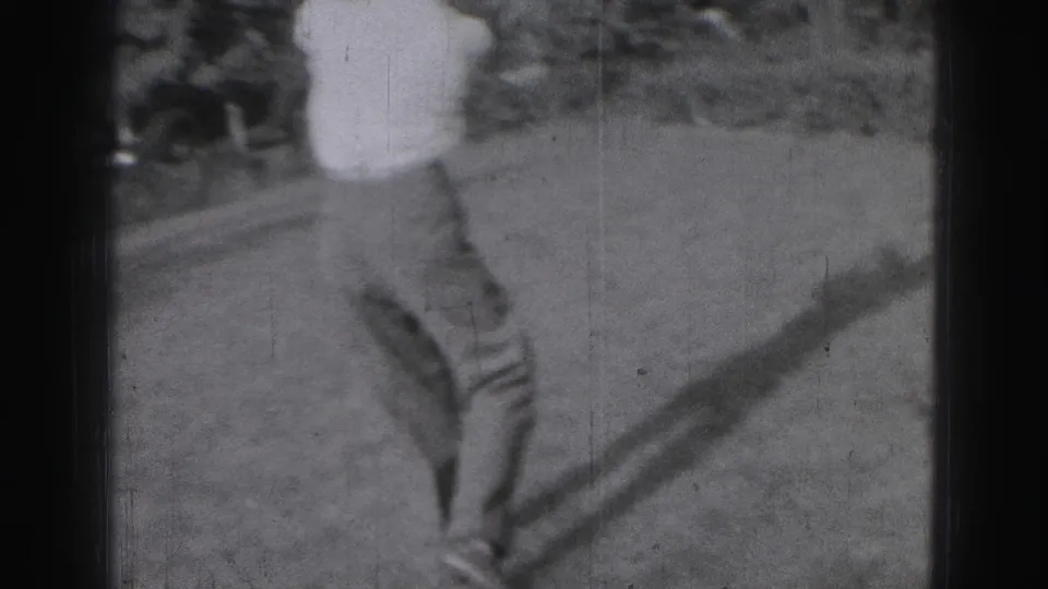 Soft black-and-white 1946 Harrisburg home-movie frame showing a golfer on grass, partly cropped as he prepares or follows through.
