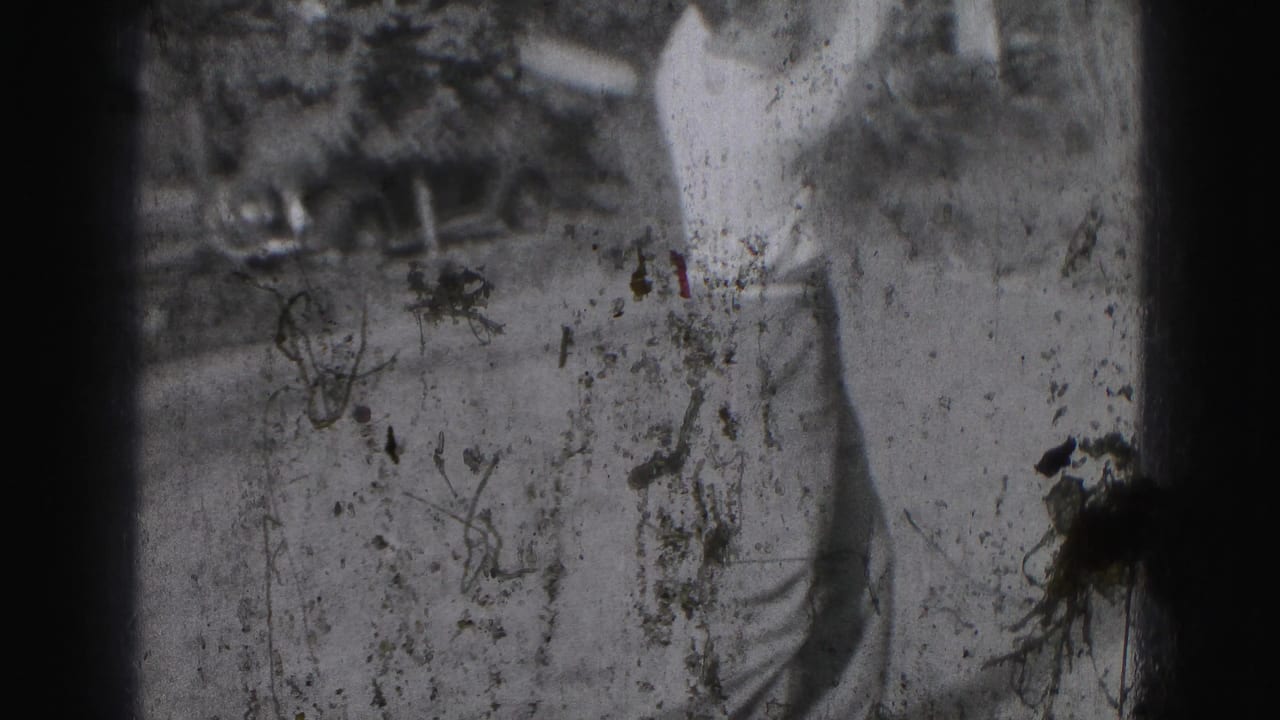 Motion-blurred 1946 home-movie frame shows the golfer during a swing, with grass, trees, and a parked car partly visible.