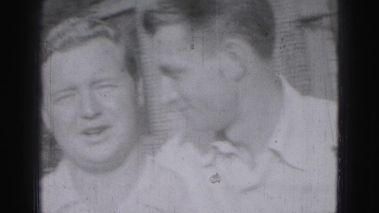 Three adult men stand close together and smile toward the camera.
