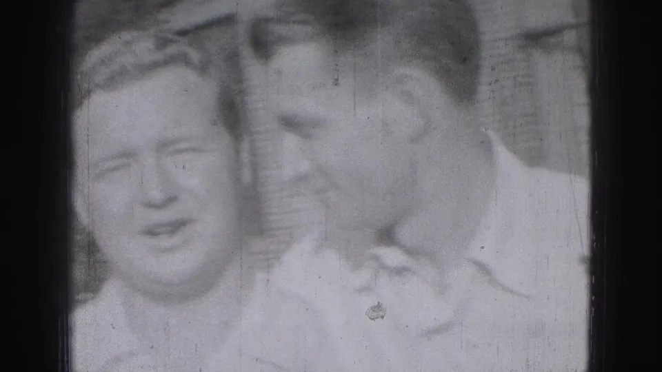 Three adult men in light-colored shirts pose closely outdoors in Harrisburg, Pennsylvania, in a 1946 8mm frame.