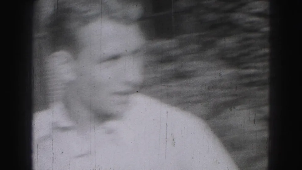 A soft, motion-blurred 1946 Harrisburg frame shows a man in a light shirt close to the camera with another face partly visible.