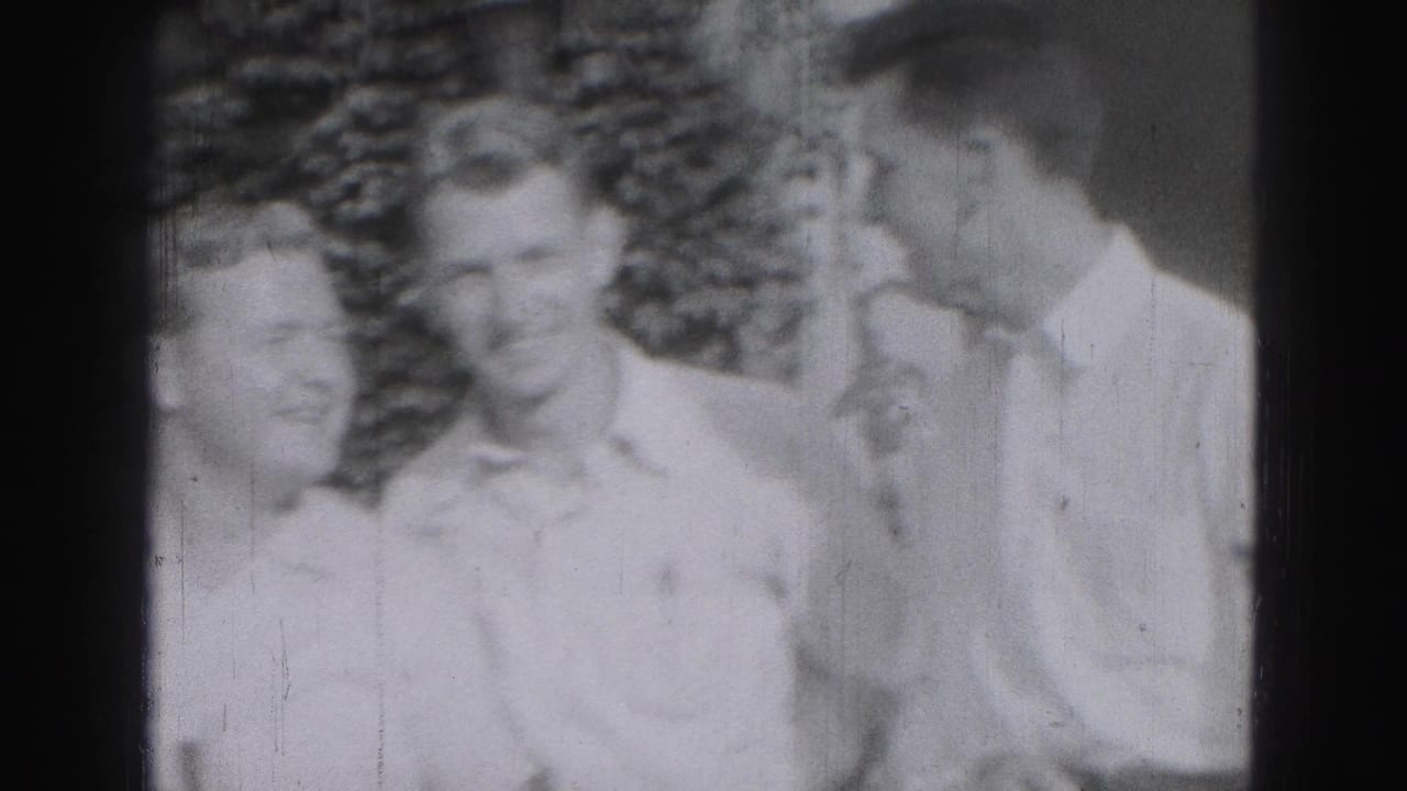 Three young men in light shirts stand outdoors in soft-focus black-and-white footage.