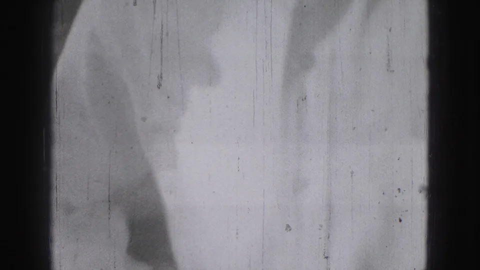 Soft, blurred 1946 8mm frame from Harrisburg showing a partial adult figure near a pale wall or doorway.