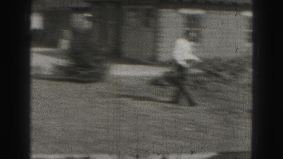 Blurred 1946 8mm frame from Harrisburg showing an adult man moving near a house exterior and yard area.
