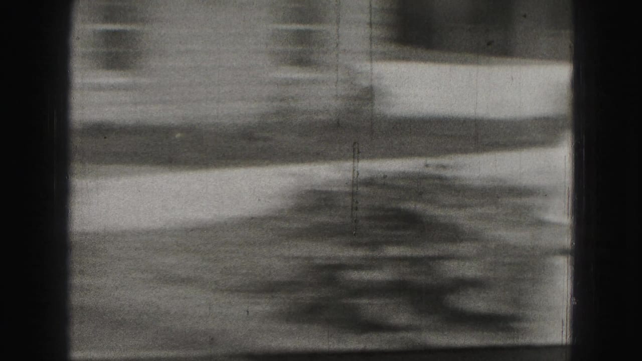 Blurred view of a yard or ground surface with strong shadows and film frame edges.