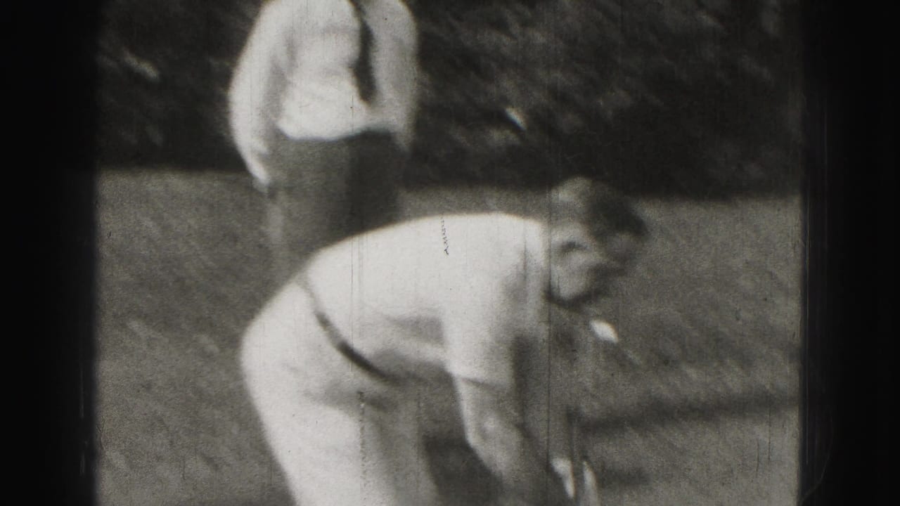 Men on a lawn during a croquet game, with one player bending near the foreground.
