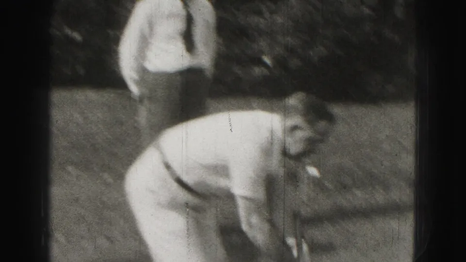 1946 Harrisburg home-movie frame showing men in light clothing playing croquet on a residential lawn.