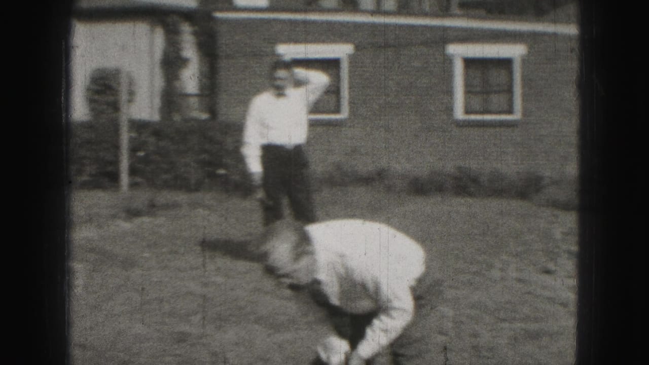 In 1946 Harrisburg home-movie footage, one adult man bends toward a croquet shot as another stands near a house and lawn.
