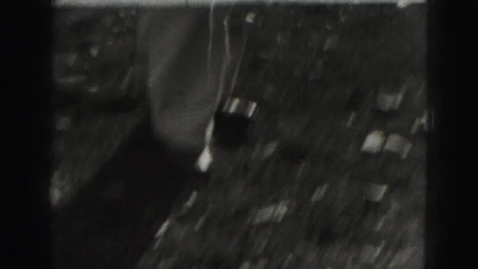 Soft, dark 1946 8mm frame from Harrisburg showing a blurred yard scene with indistinct croquet players or equipment.