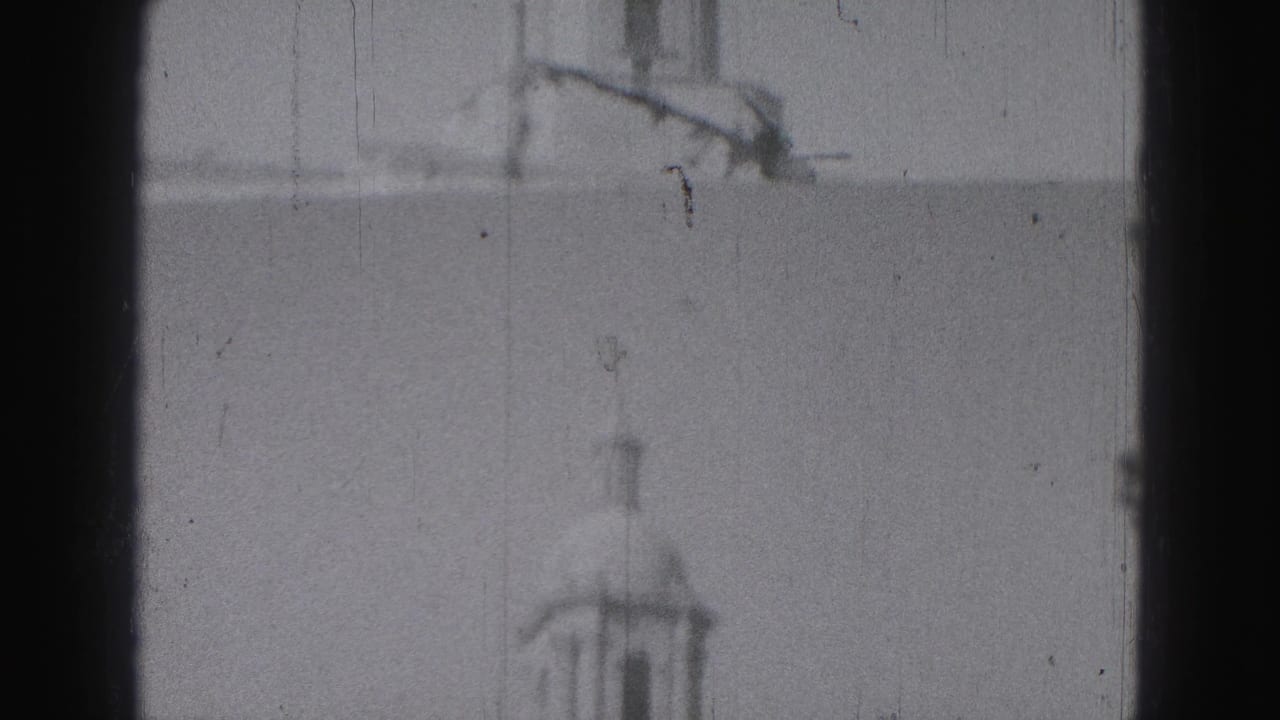 1946 Harrisburg footage showing a distant domed tower and roofline above a classical public building, framed by dark film edges.