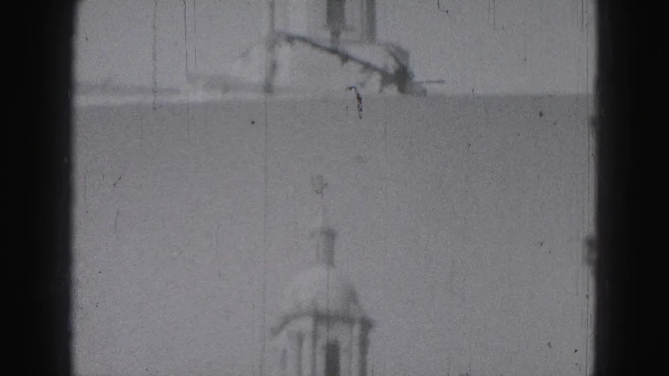 1946 Harrisburg footage showing a distant domed tower and roofline above a classical public building, framed by dark film edges.